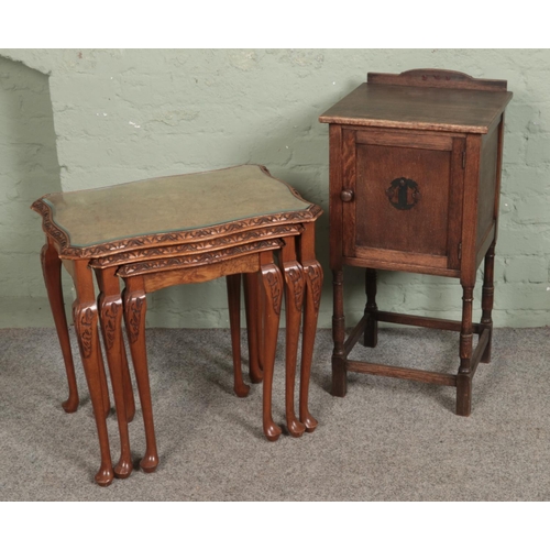 516 - A nest of three tables with walnut quarter veneer tops along with oak pot cupboard