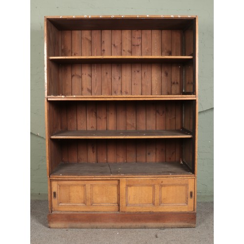 552 - An Elliott & Sons large oak fronted pine stacking shop fitting cabinet, with slatted back. Featuring... 