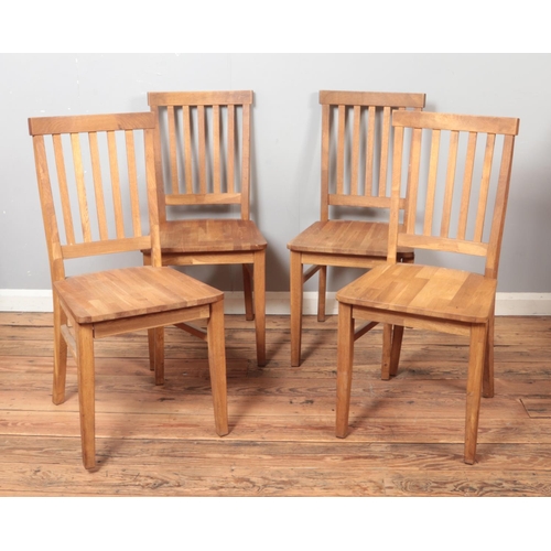 516 - A set of four oak slat back dining chairs.