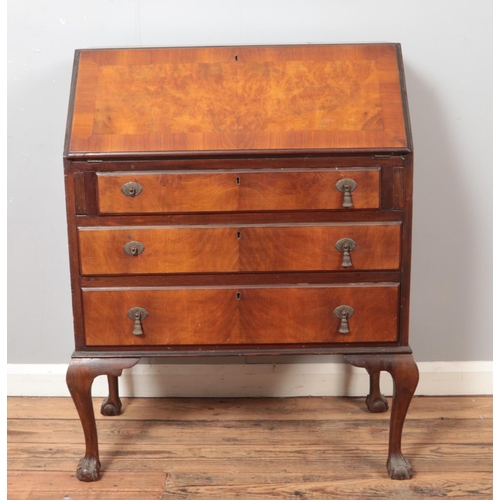 523 - An early 20th century walnut bureau raised on ball and claw feet.