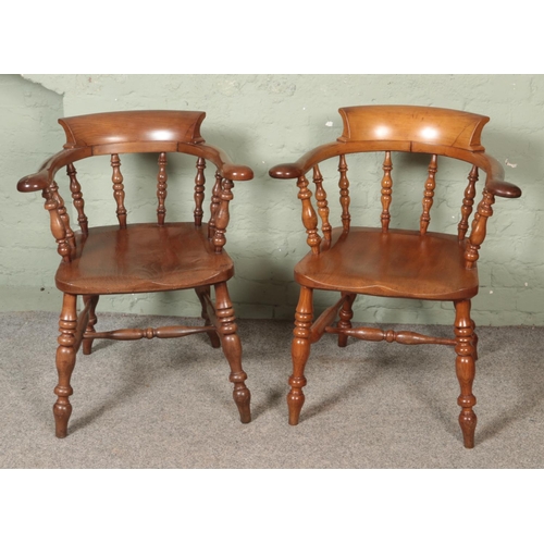 530 - A near pair of beech and elm smokers bow armchairs.