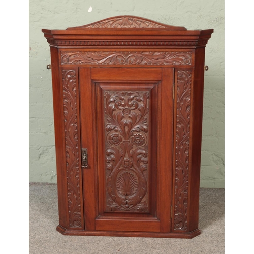 531 - A heavily carved oak corner cabinet