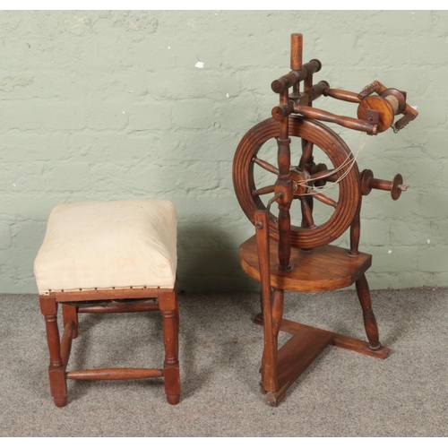 542 - A vintage wooden spinning wheel along with small cushioned stool.