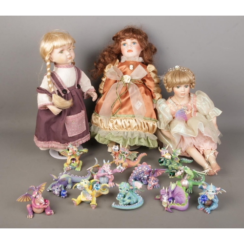 102 - A collection of boxed Mood Dragons together with three porcelain dolls including examples from the L... 