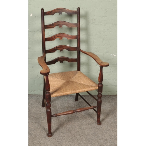 549 - An early 20th century arts and crafts style ladder back elbow chair