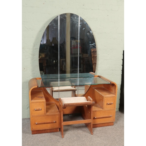 561 - An Art Deco style G Plan E Gomme oak mirrored dressing table, with glass shelf and three piece large... 