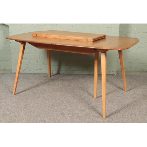 563 - An Ercol 'Grand Windsor' light oak and ash extending dining table, with hinged additional leaf, roun... 