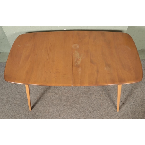 563 - An Ercol 'Grand Windsor' light oak and ash extending dining table, with hinged additional leaf, roun... 