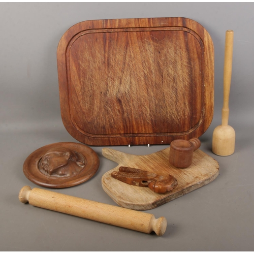 130 - A collection of treen to include chopping boards, carved nutcracker, portrait relief, etc.