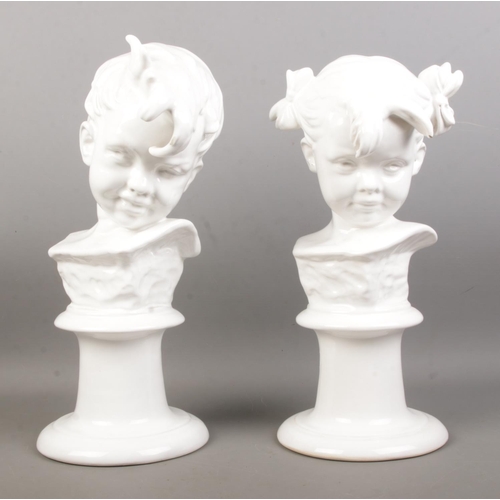 32 - A pair of white glazed ceramic busts, depicting a boy and girl. Raised on turned stepped bases. Heig... 