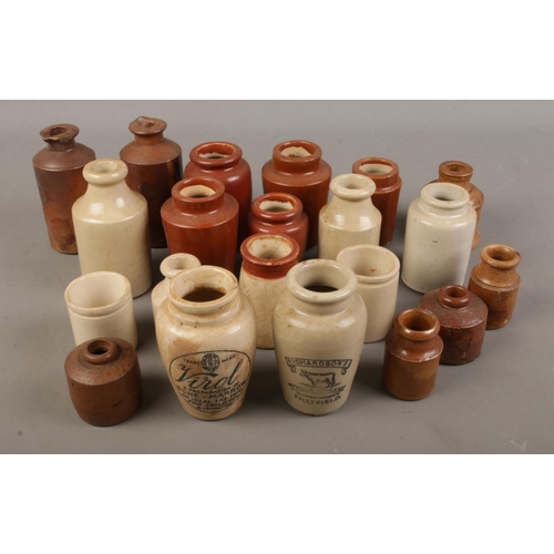 63 - A collection of small stoneware bottles including some being labelled 