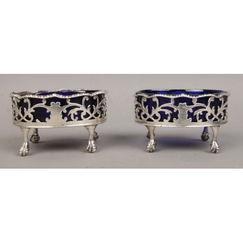 460 - A near pair of Georgian silver salts, with Bristol blue glass liners, raised on ball and claw feet. ... 