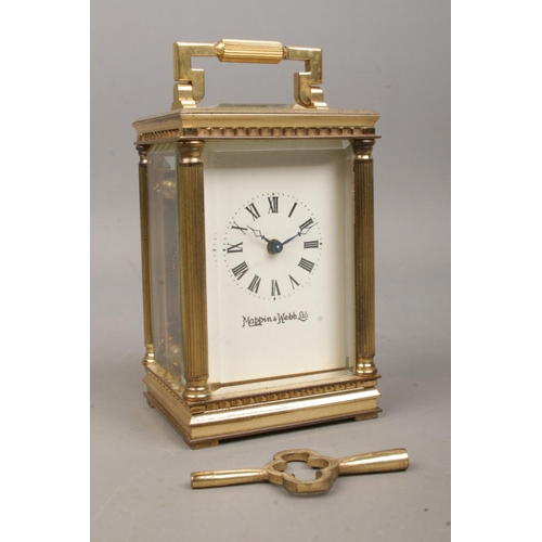 461 - A miniature brass Mappin and Webb carriage clock, with Corinthian column supports to the corners, wh... 