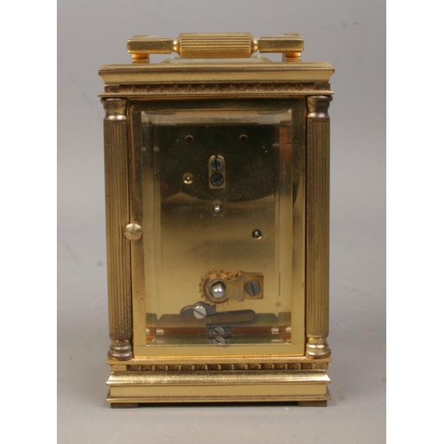 461 - A miniature brass Mappin and Webb carriage clock, with Corinthian column supports to the corners, wh... 