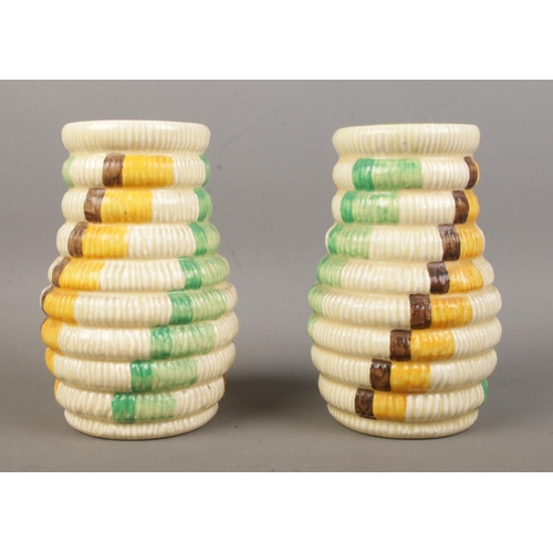 477 - A pair of Clarice Cliff vases in the 'Raffia' pattern. Bearing factory stamps and 722 to the base. 1... 