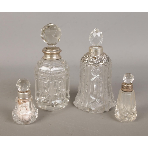 495 - Four silver collared perfume bottles to include bell shaped example with floral decoration. Hallmark... 