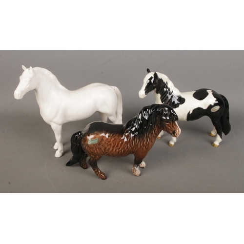 96 - Three Beswick ceramic horses to include Palamino and Shetland examples. All with various repairs.