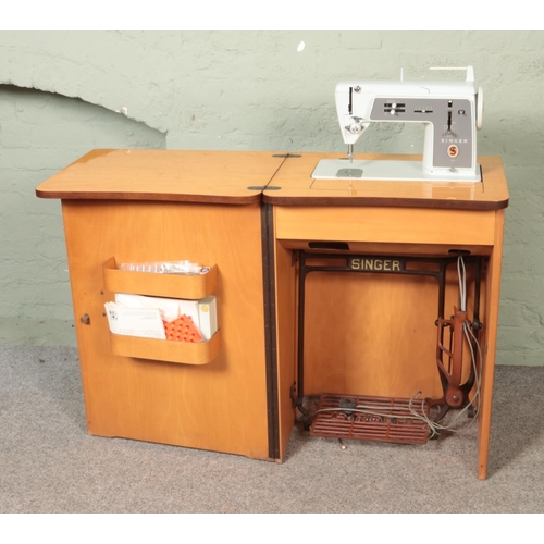 523 - A vintage Singer sewing machine cabinet along with small quantity of haberdashery. Machine model 611... 