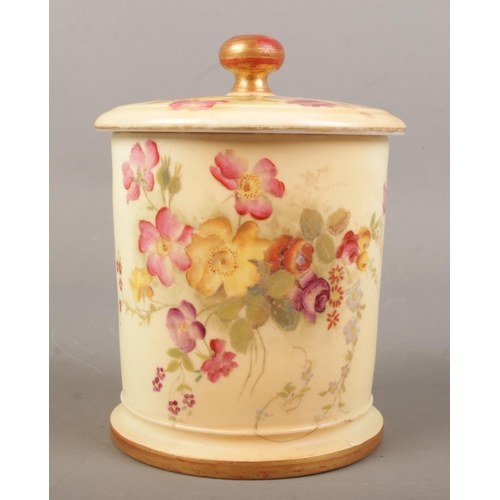 492 - A Royal Worcester blush ivory lidded pot with hand painted floral decoration. Date mark for 1896. He... 