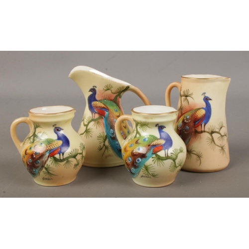 501 - Four small Locke & Co Worcester jugs. All hand painted and decorated with a peacock. Signed H Wall. ... 