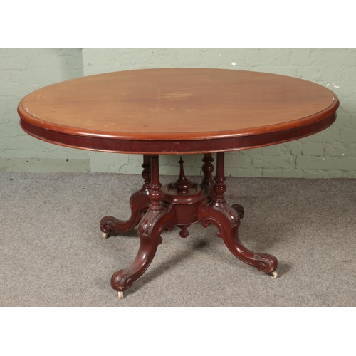 524 - A mahogany breakfast table with oval top and carved base