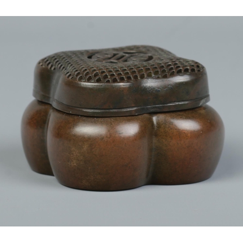 10 - A Chinese bronze hand warmer of lobed form, having pierced cover. Character marks to base. 4cm x 6.5... 