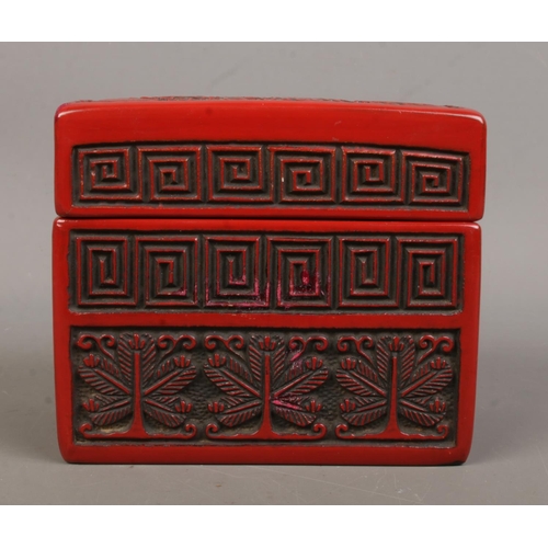 11 - A Chinese cinnabar lacquer card box. The cover decorated with a landscape scene. 9cm x 11cm x 6.5cm.