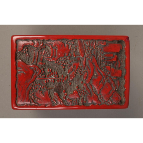 11 - A Chinese cinnabar lacquer card box. The cover decorated with a landscape scene. 9cm x 11cm x 6.5cm.