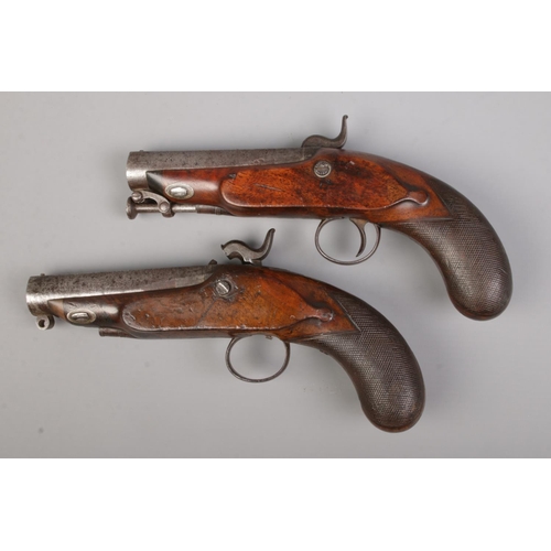 111 - A pair of 19th century percussion pistols. The lock plates marked for IM Burnie. Total length 21cm. ... 