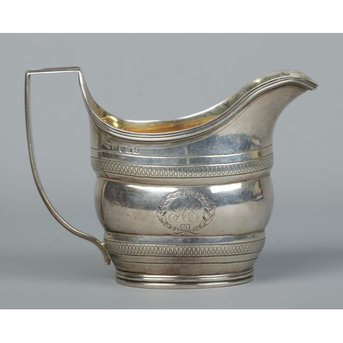 140 - A George III silver cream jug with engraved decoration and gilt interior. Assayed London 1801 by Wil... 