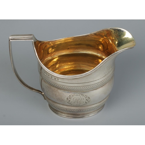 140 - A George III silver cream jug with engraved decoration and gilt interior. Assayed London 1801 by Wil... 