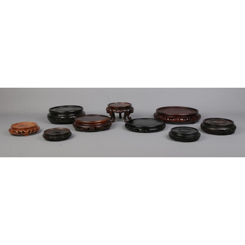 15 - Nine Chinese carved hardwood stands of various sizes. Largest 18.5cm, Smallest 8.5cm.