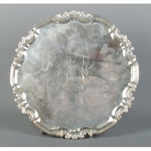 152 - A George II silver salver raised on three scrolled feet. Assayed London 1747. Diameter 30.5cm. 968g.