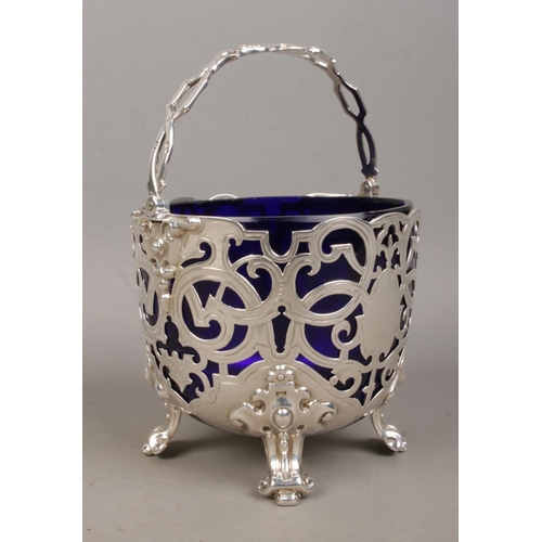 159 - A Victorian silver pierced basket with swing handle and Bristol blue glass liner. Assayed London 186... 