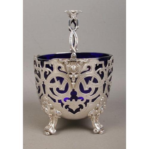 159 - A Victorian silver pierced basket with swing handle and Bristol blue glass liner. Assayed London 186... 