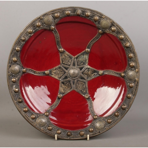 17 - A 20th century Moroccan glazed terracotta dish with metal mounts and adorned with Moroccan coins. Th... 