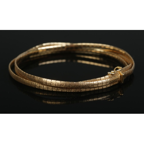 186 - An 18ct gold three band flat link bracelet. Stamped 750 20 VR. 20.73g.