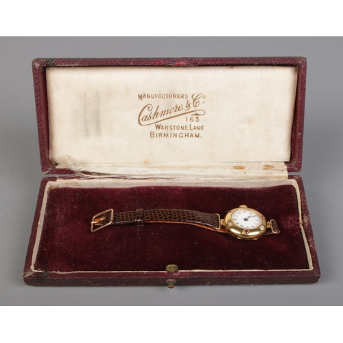 213 - A ladies 18ct gold, diamond and ruby manual wristwatch on leather strap with 9ct gold buckle.