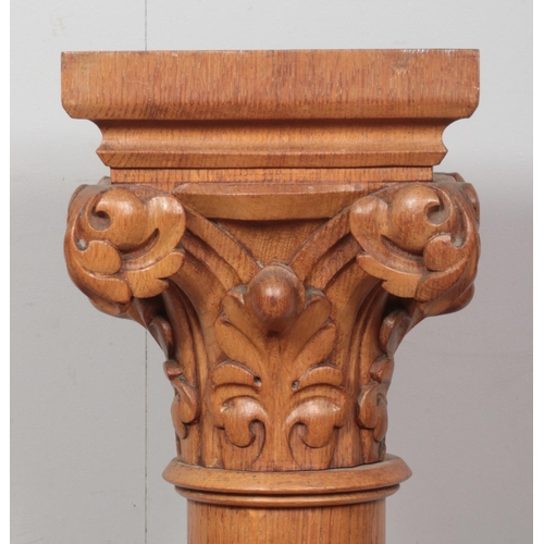 253 - A pair of carved oak columns raised on stepped bases. Having scrolled acanthus leaf decoration. Heig... 