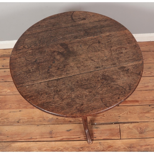 254 - A Georgian oak circular tripod occasional table. Diameter of top 81cm.