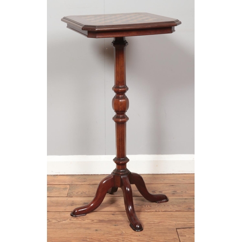 261 - A Victorian inlaid mahogany games table raised on centre column and four supports. Height 80cm.