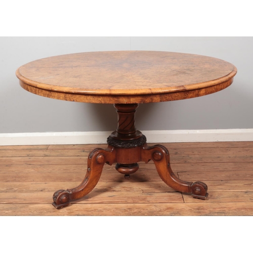 264 - A Victorian walnut tilt top supper table with quarter veneered top and raised on carved tripod suppo... 