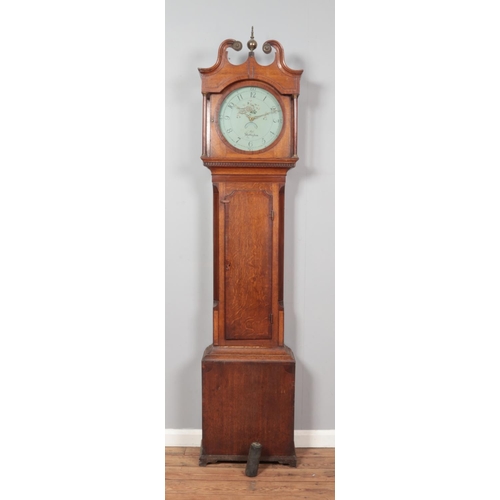 265 - A Georgian oak longcase clock. Having twin swan neck pediment and painted enamel dial marked for Mos... 