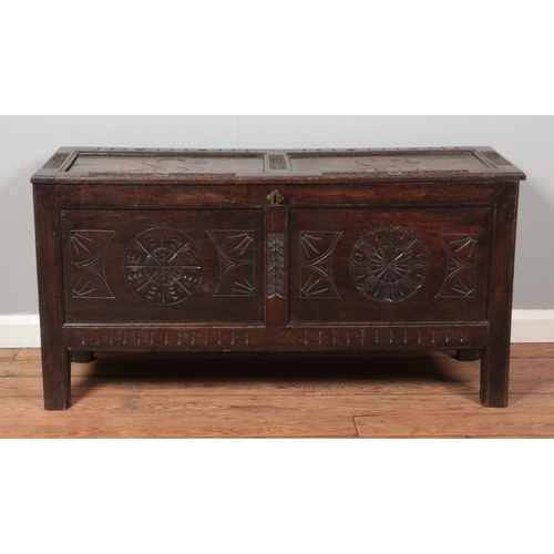 266 - A period carved and panelled oak coffer. 60cm x 118cm x 43cm.