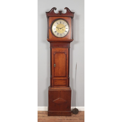 271 - A Georgian oak and mahogany long case clock. Having twin swan neck pediment and circular brass dial.