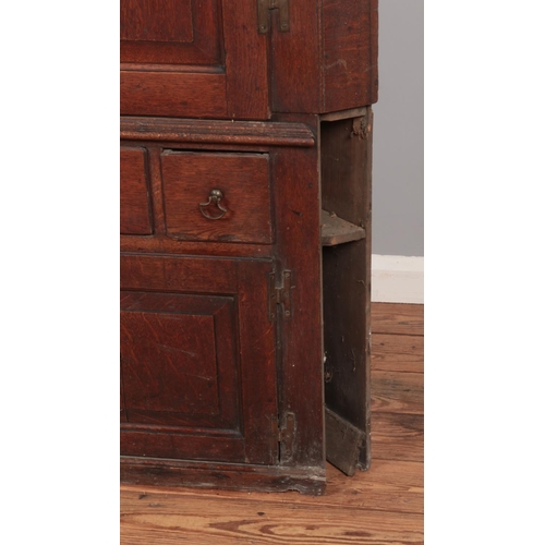 273 - A large Georgian oak corner cupboard raised on drawer and cupboard base. Height 192cm, Width 128cm.