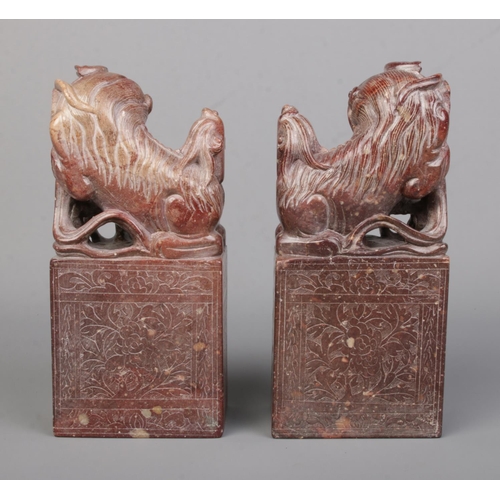 3 - A pair of Chinese carved hardstone bookends modelled as Dog of Fo/Temple Lions raised on plinths. He... 