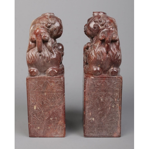 3 - A pair of Chinese carved hardstone bookends modelled as Dog of Fo/Temple Lions raised on plinths. He... 