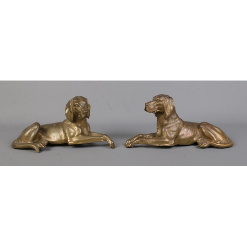 57 - A pair of bronze sculptures modelled as recumbent dogs. Length 27cm.