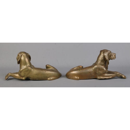 57 - A pair of bronze sculptures modelled as recumbent dogs. Length 27cm.